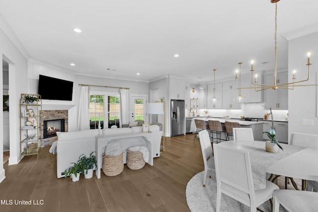 118 Seymour Dr, Madison, MS 39110 - living room with ornamental molding, wood finished floors, recessed lighting, a lit fireplace, and a chandelier