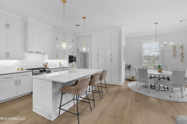 118 Seymour Dr, Madison, MS 39110 - kitchen featuring stainless steel appliances, white cabinets, tasteful backsplash, and light wood-style flooring
