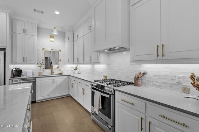 118 Seymour Dr, Madison, MS 39110 - kitchen with stainless steel range with gas cooktop, white cabinetry, decorative backsplash, recessed lighting, and light wood-type flooring