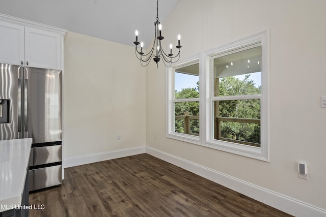 unfurnished dining area featuring a notable chandelier, lofted ceiling, and dark hardwood / wood-style floors