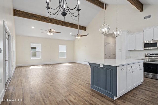 kitchen with beam ceiling, wood-type flooring, a center island, white cabinetry, and appliances with stainless steel finishes