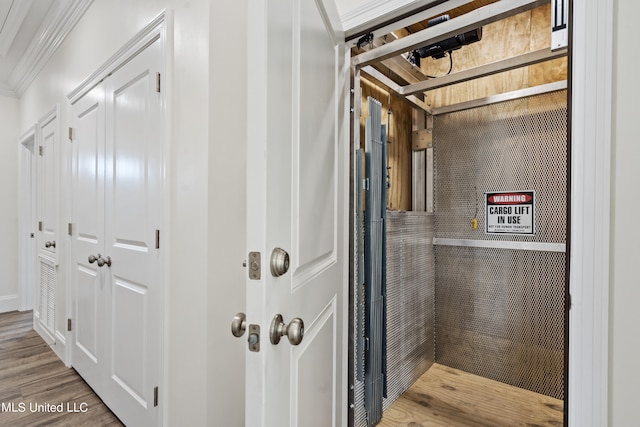 bathroom featuring ornamental molding and wood-type flooring