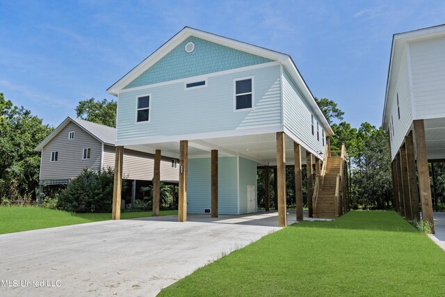 back of house featuring a lawn and a carport