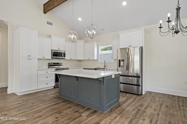 kitchen featuring dark hardwood / wood-style flooring, appliances with stainless steel finishes, beamed ceiling, and white cabinets