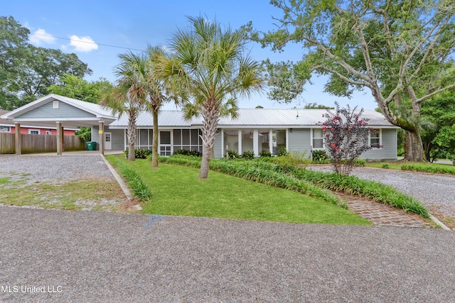 ranch-style home with a front lawn, a sunroom, and a carport