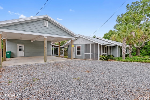 rear view of property featuring a carport and a sunroom