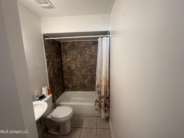 bathroom featuring toilet, tile patterned flooring, a textured ceiling, and shower / bath combo