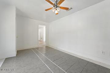 tiled spare room with ceiling fan