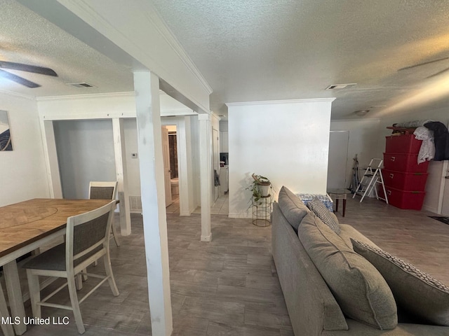 interior space with a textured ceiling, ceiling fan, and crown molding