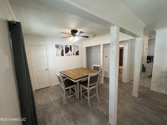 dining area with ceiling fan, dark wood-type flooring, a textured ceiling, and ornamental molding