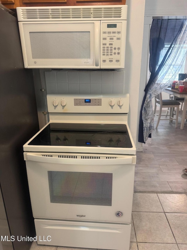 interior details featuring decorative backsplash and white appliances