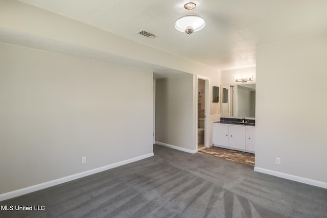 2802 Ridgewood Ave, Pascagoula, MS 39567 - unfurnished bedroom with dark colored carpet, baseboards, a sink, and ensuite bath