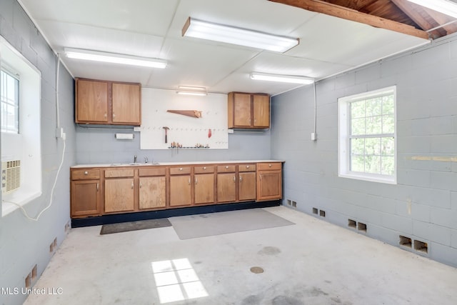2802 Ridgewood Ave, Pascagoula, MS 39567 - kitchen with unfinished concrete floors, brown cabinets, light countertops, open shelves, and concrete block wall