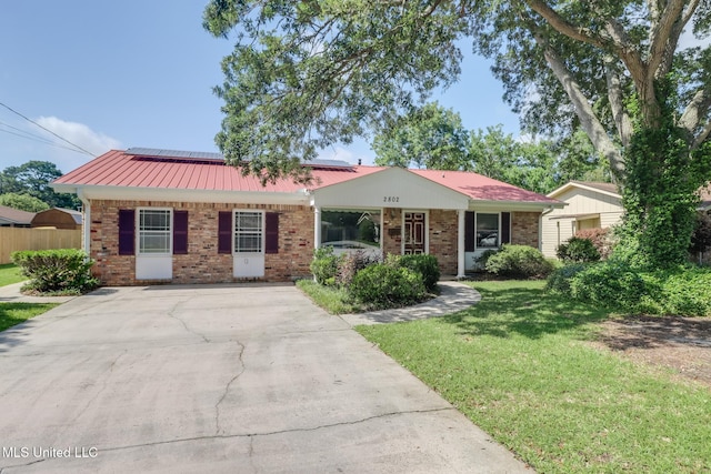 2802 Ridgewood Ave, Pascagoula, MS 39567 - ranch-style house with brick siding, roof mounted solar panels, and concrete driveway