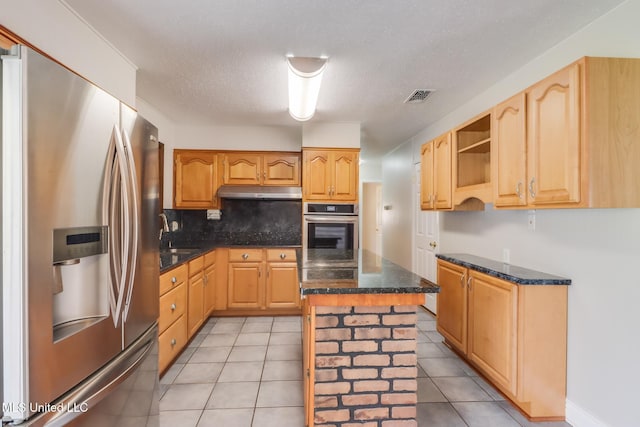 2802 Ridgewood Ave, Pascagoula, MS 39567 - kitchen featuring stainless steel appliances, decorative backsplash, a kitchen island, under cabinet range hood, and dark stone counters
