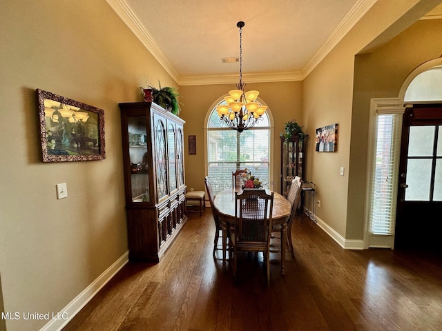 dining area with dark wood-type flooring, crown molding, and a chandelier