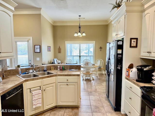 kitchen featuring sink, a notable chandelier, pendant lighting, light tile patterned floors, and black appliances