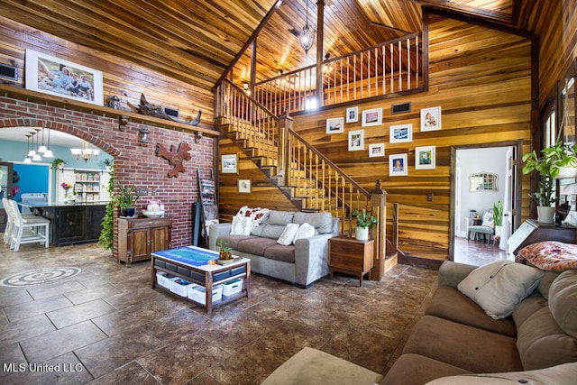 living room with wood ceiling, wooden walls, a chandelier, high vaulted ceiling, and beam ceiling