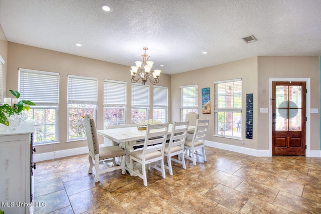 dining room with a chandelier and a textured ceiling