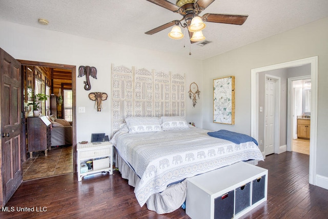 bedroom with dark wood-type flooring, a textured ceiling, and ceiling fan