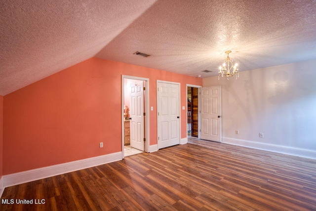 bonus room with an inviting chandelier, lofted ceiling, a textured ceiling, and dark hardwood / wood-style floors