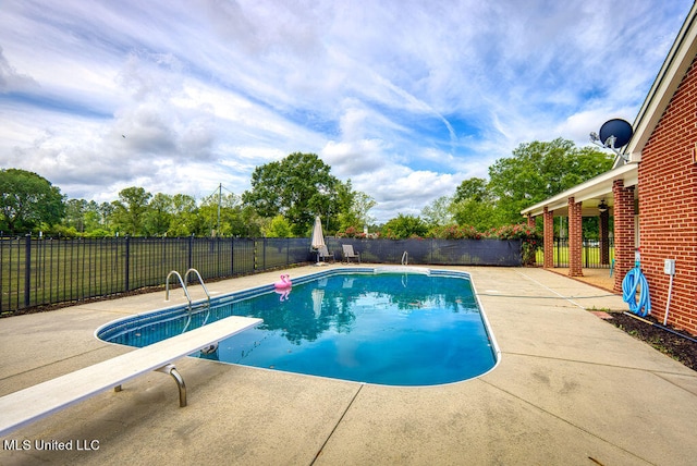 view of pool featuring a diving board and a patio