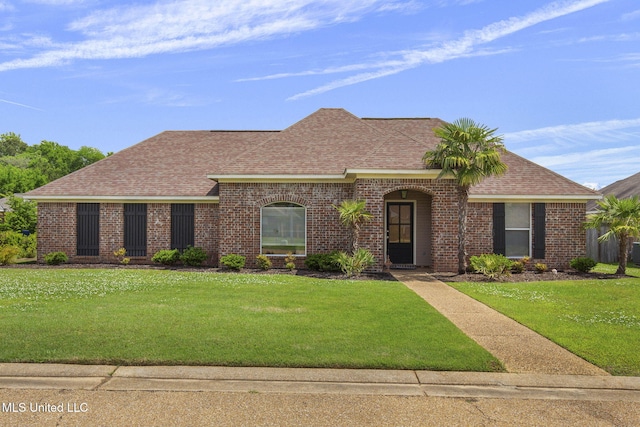 ranch-style house featuring brick siding, a shingled roof, and a front lawn