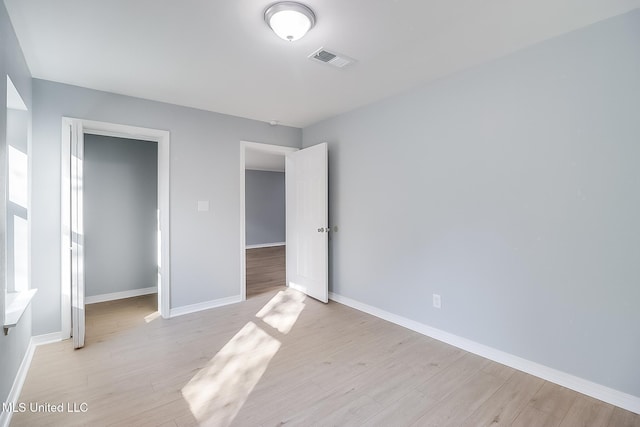 unfurnished bedroom featuring light wood-type flooring and a closet