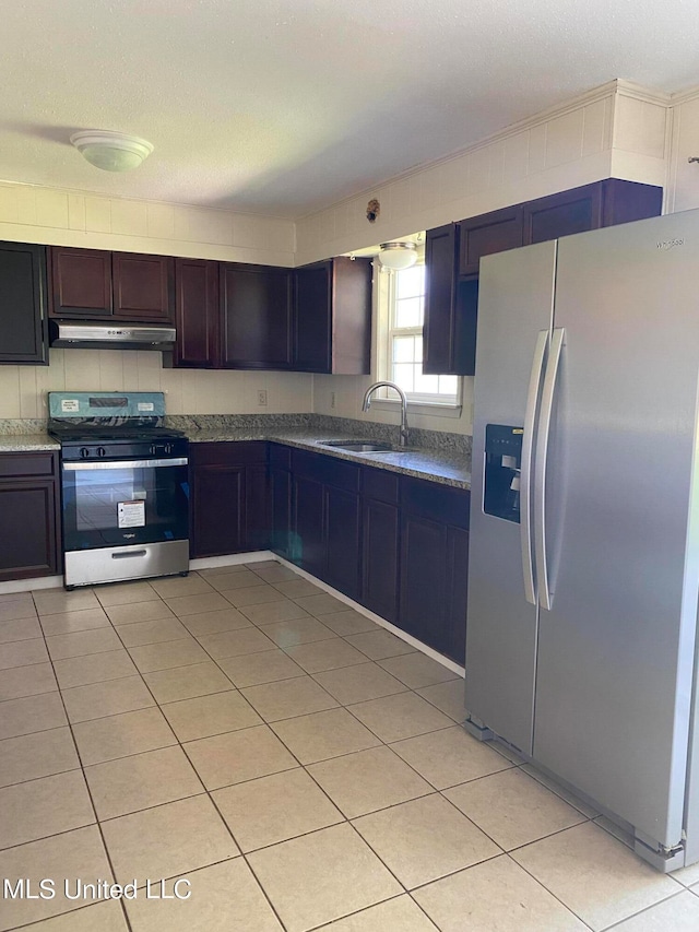 kitchen featuring appliances with stainless steel finishes, dark brown cabinetry, sink, and light tile patterned floors