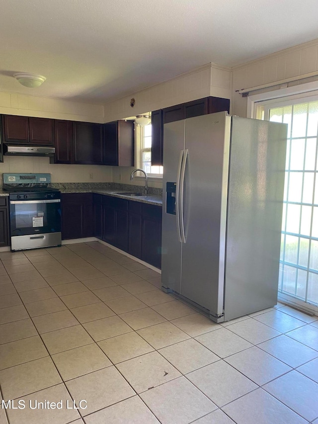 kitchen with light tile patterned floors, stainless steel appliances, sink, and a wealth of natural light