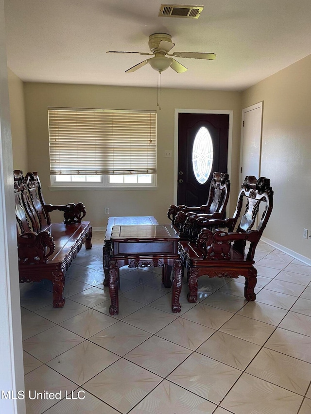 interior space with light tile patterned floors and ceiling fan