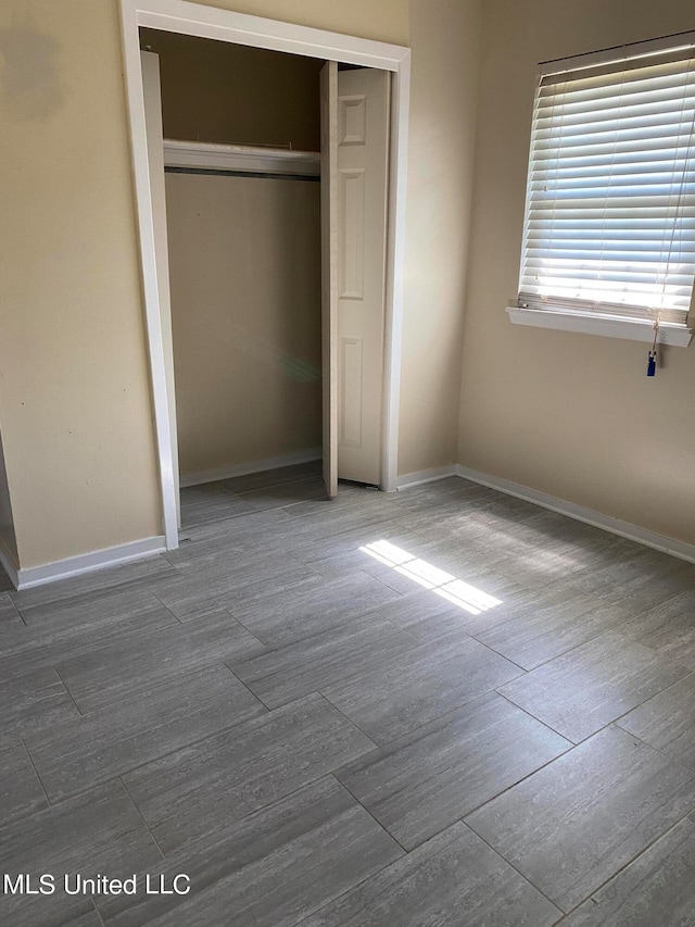 unfurnished bedroom featuring dark hardwood / wood-style floors and a closet