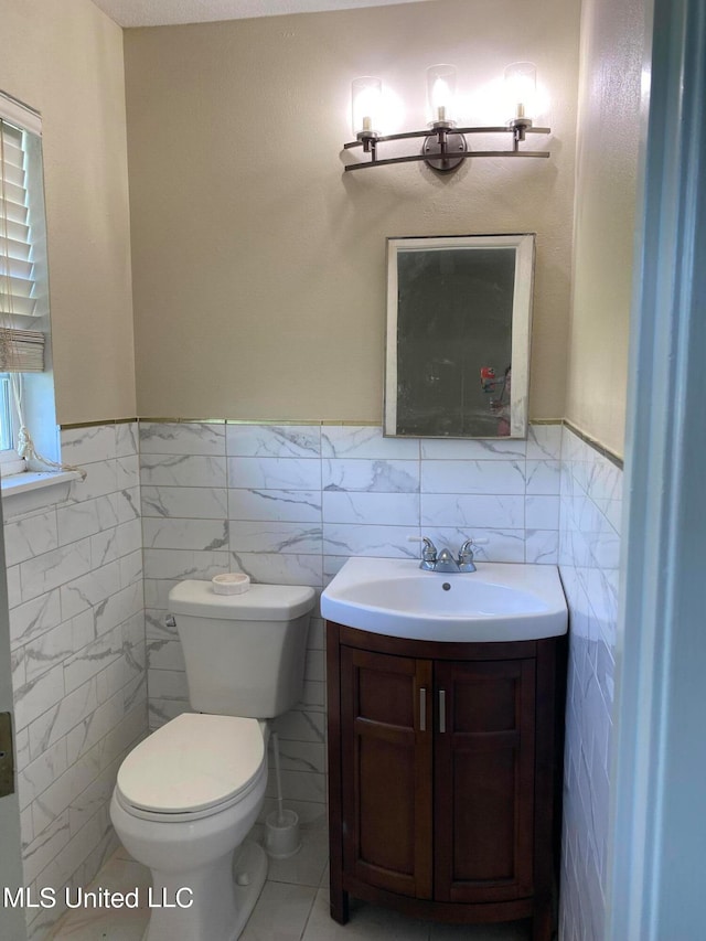 bathroom with tile walls, vanity, and toilet