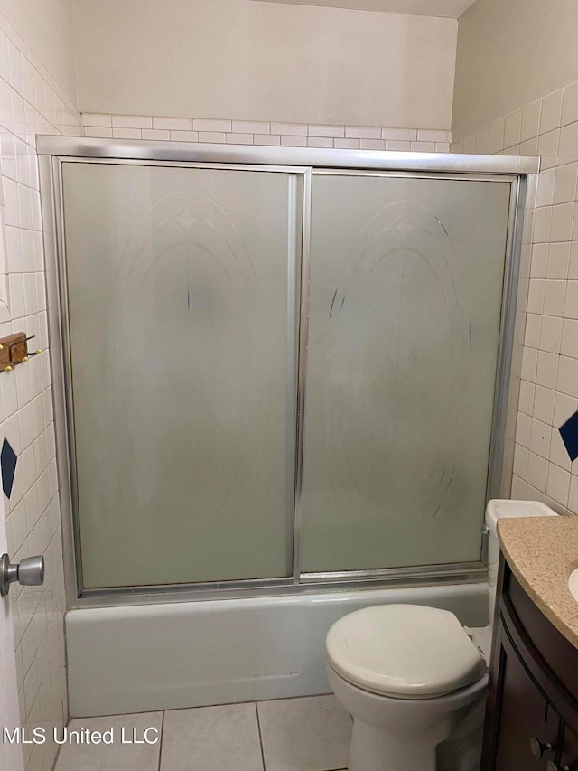 full bathroom with vanity, toilet, shower / bath combination with glass door, and tile patterned flooring