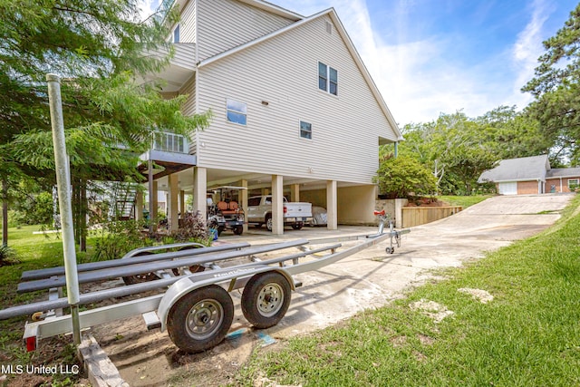 back of property featuring a carport and a lawn