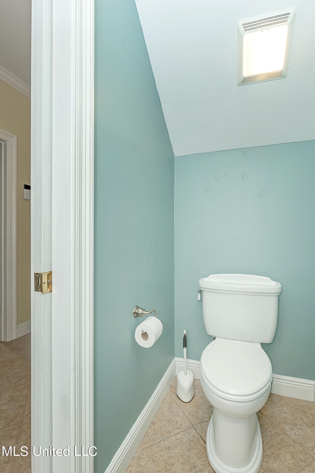 bathroom featuring toilet, crown molding, vaulted ceiling, and tile patterned flooring