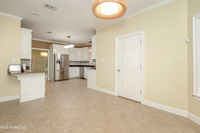 kitchen featuring decorative backsplash, kitchen peninsula, stainless steel appliances, a kitchen bar, and white cabinets