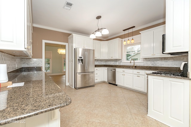 kitchen with crown molding, white cabinets, hanging light fixtures, and stainless steel appliances