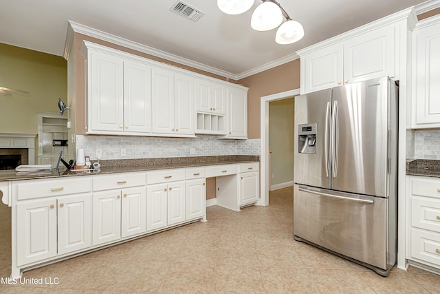 kitchen with pendant lighting, white cabinets, crown molding, decorative backsplash, and stainless steel refrigerator with ice dispenser