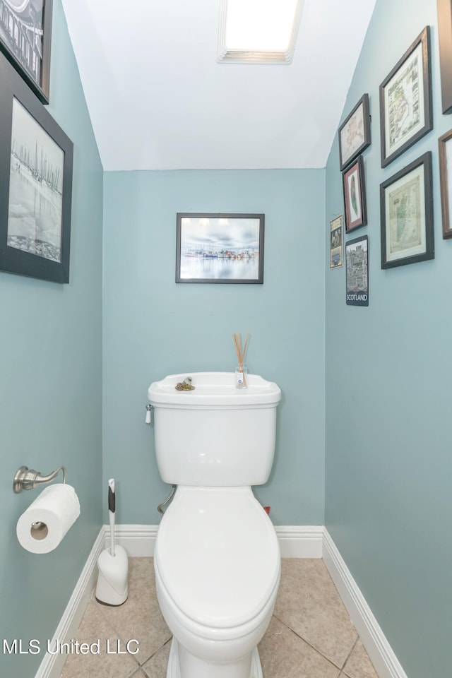 bathroom featuring toilet, tile patterned floors, and vaulted ceiling