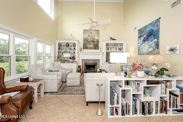 living room with ceiling fan, a towering ceiling, light tile patterned floors, and plenty of natural light