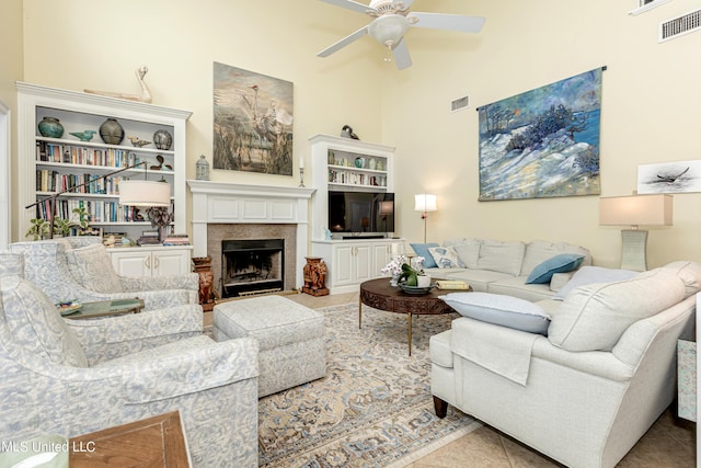 living room featuring a towering ceiling, ceiling fan, and light tile patterned floors