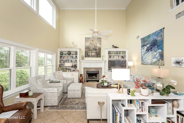 tiled living room featuring ornamental molding, a towering ceiling, and ceiling fan