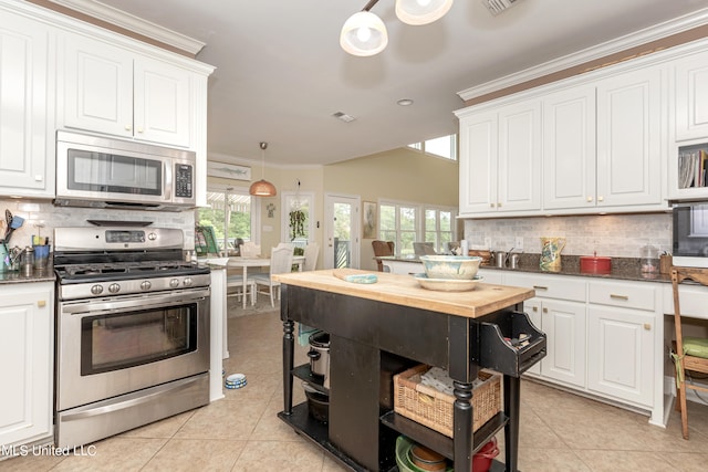 kitchen featuring ornamental molding, appliances with stainless steel finishes, white cabinets, and tasteful backsplash