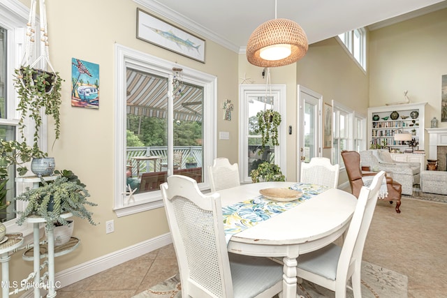 tiled dining room featuring ornamental molding and plenty of natural light