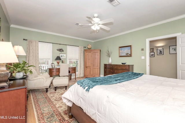 bedroom featuring crown molding, light hardwood / wood-style floors, and ceiling fan