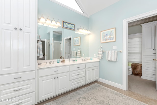 bathroom with vanity, vaulted ceiling, and walk in shower