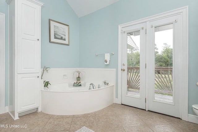 bathroom with tile patterned floors, vaulted ceiling, and plenty of natural light