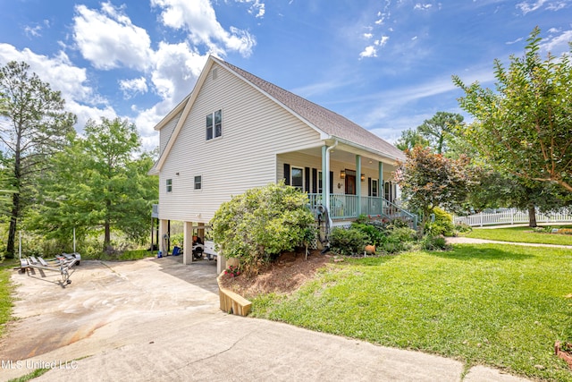 view of property exterior featuring covered porch, a lawn, and a carport