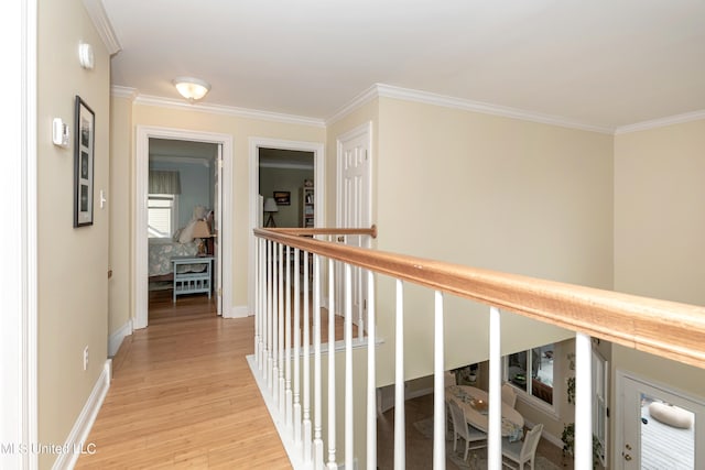 hallway with light hardwood / wood-style flooring and crown molding